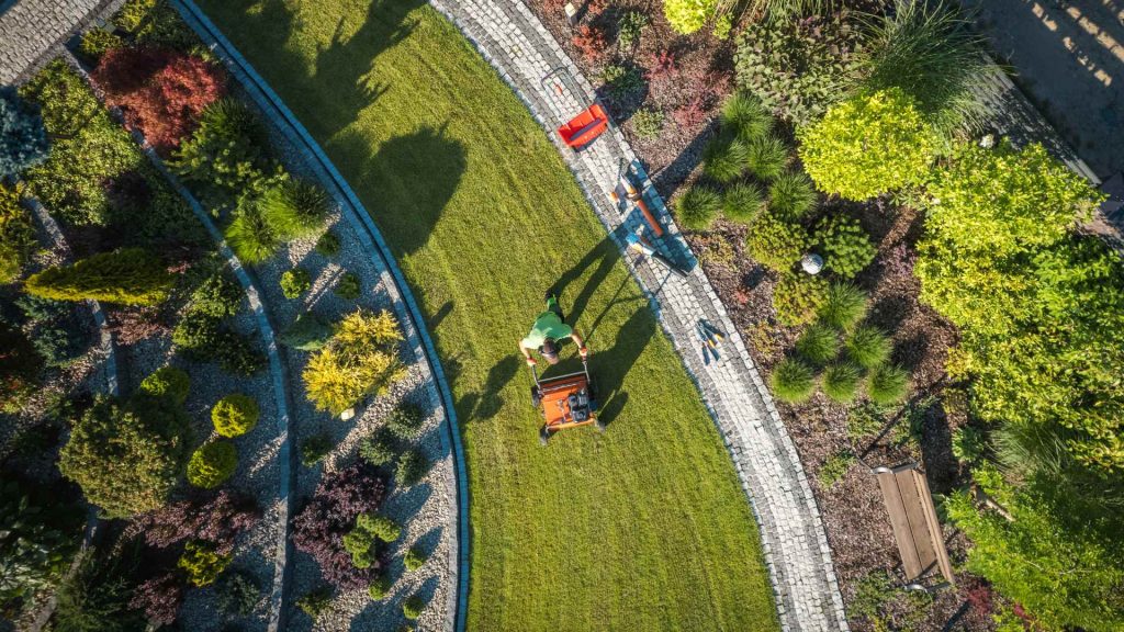 Man mowing a commercial property to upkeep the perfect lawn.